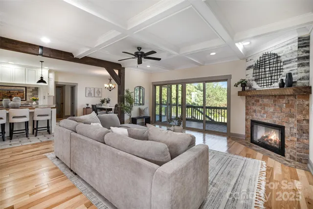 a living room with furniture a fireplace and a floor to ceiling window