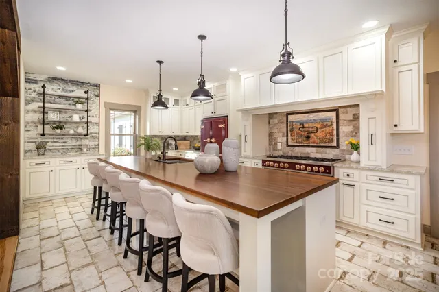 a kitchen with stainless steel appliances a table a stove a refrigerator and cabinets