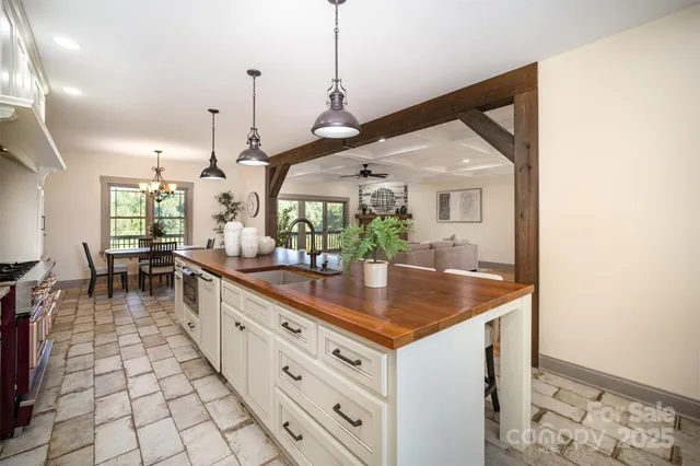 a kitchen with stainless steel appliances granite countertop a sink a stove and a wooden floors