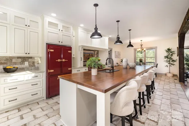 a kitchen with kitchen island a counter top space a sink stainless steel appliances and cabinets