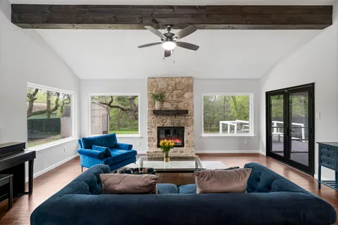 a living room with furniture a fireplace and large window