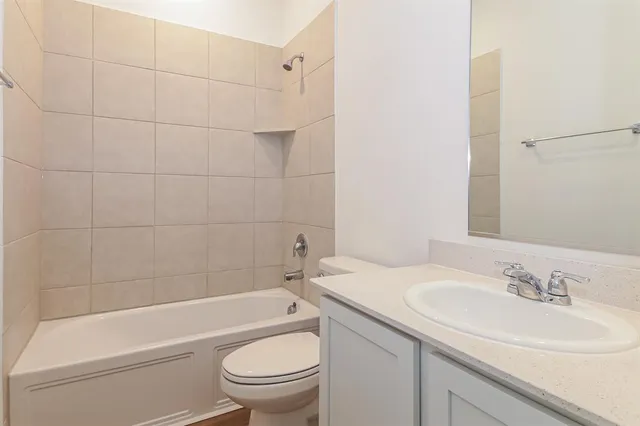a bathroom with a sink toilet vanity and shower