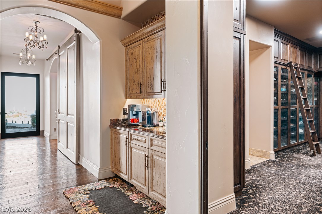 1123 Christian Road Henderson, NV 89002 - Photo 20 of 94 Rich hardwood flooring leads to a grand entrance with elegant chandeliers and a built-in beverage bar.
