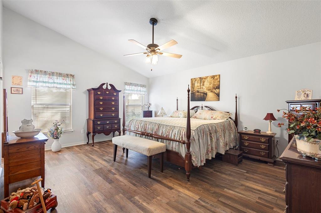 10320 Bumblebee Lane Leesburg, FL 34788 - Photo 16 of 49 a bedroom with bed and a chandelier