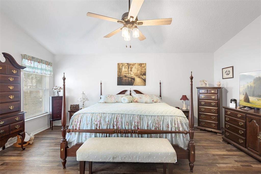 10320 Bumblebee Lane Leesburg, FL 34788 - Photo 17 of 49 a bedroom with a bed and dresser with wooden floor