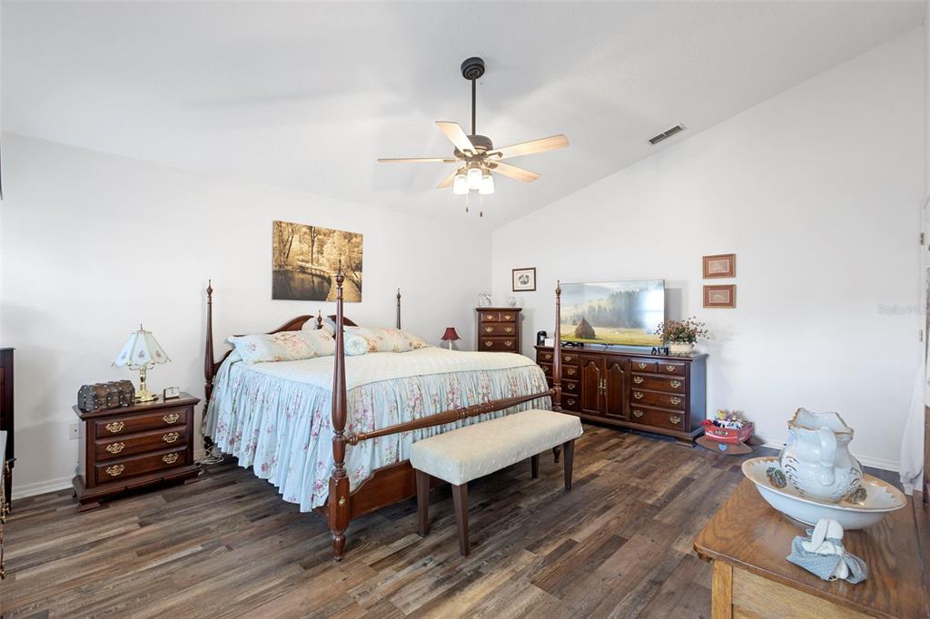 10320 Bumblebee Lane Leesburg, FL 34788 - Photo 18 of 49 a bedroom with a bed and wooden floor