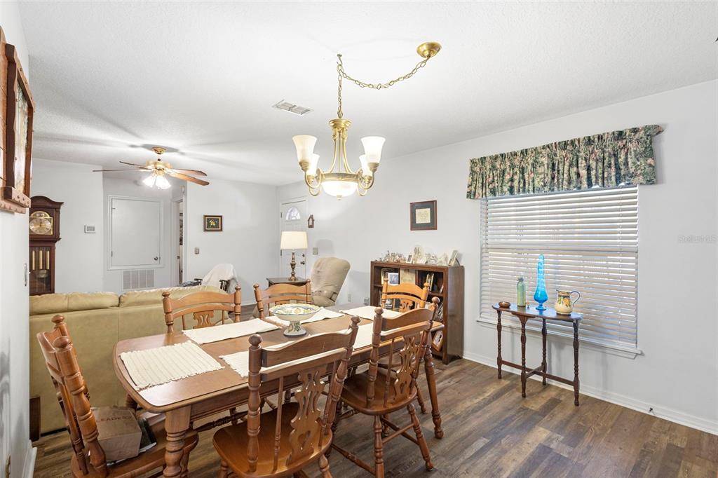 10320 Bumblebee Lane Leesburg, FL 34788 - Photo 28 of 49 a view of a dining room with furniture and wooden floor