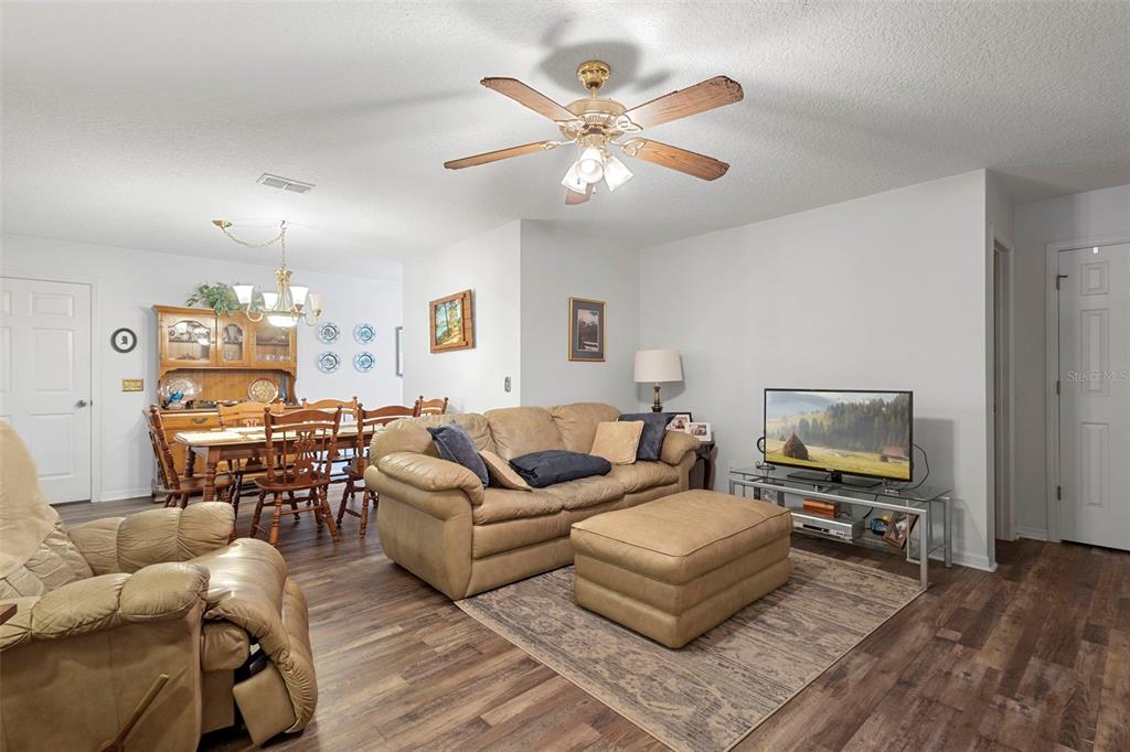 10320 Bumblebee Lane Leesburg, FL 34788 - Photo 30 of 49 a living room with furniture and a wooden floor
