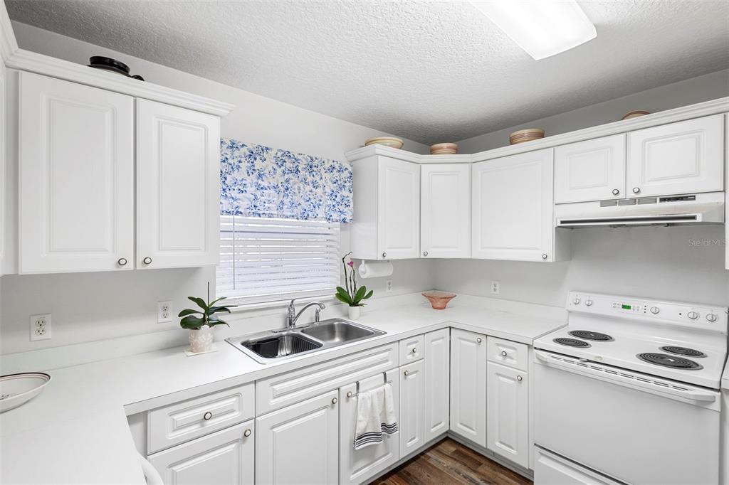 10320 Bumblebee Lane Leesburg, FL 34788 - Photo 31 of 49 a kitchen with stainless steel appliances white cabinets and a sink