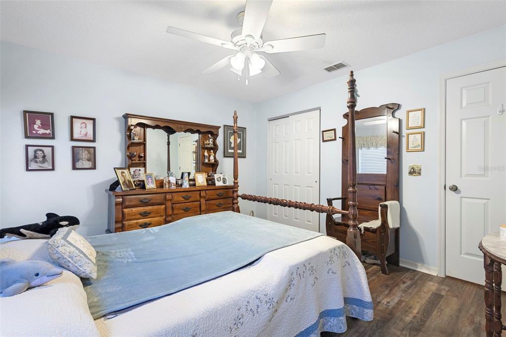 10320 Bumblebee Lane Leesburg, FL 34788 - Photo 34 of 49 a bedroom with a bed and wooden floor