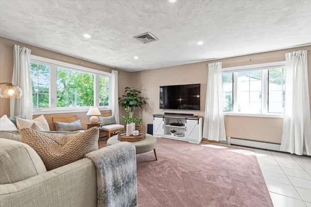 a living room with furniture a flat screen tv and a large window