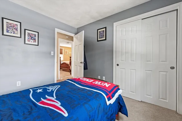 a bedroom with a bed and a painting on the wall