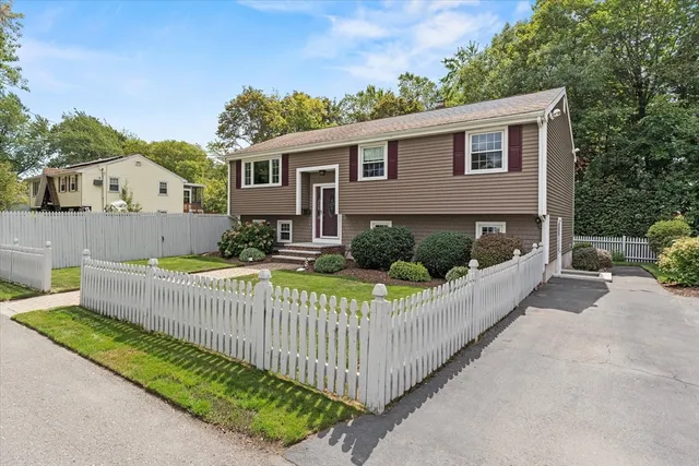 a view of a house with a small yard and wooden fence