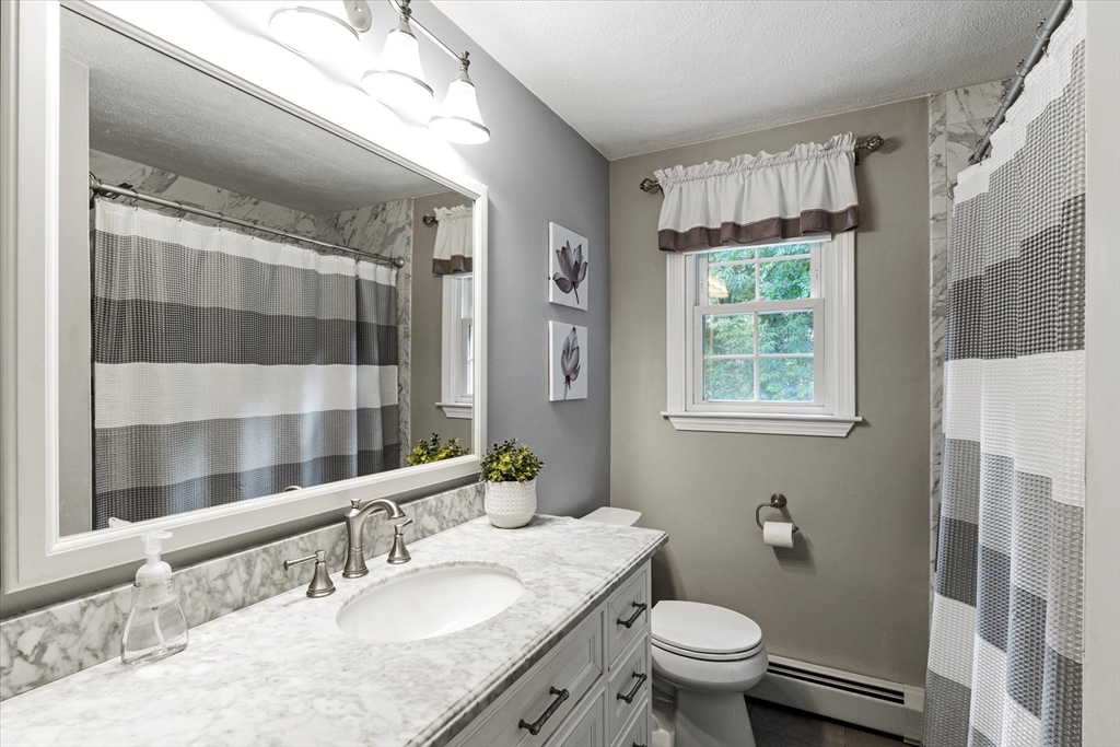 42 Crescent Saugus Ma Saugus, MA 01906 - Photo 9 of 38 a bathroom with a granite countertop sink toilet a mirror a vanity and shower