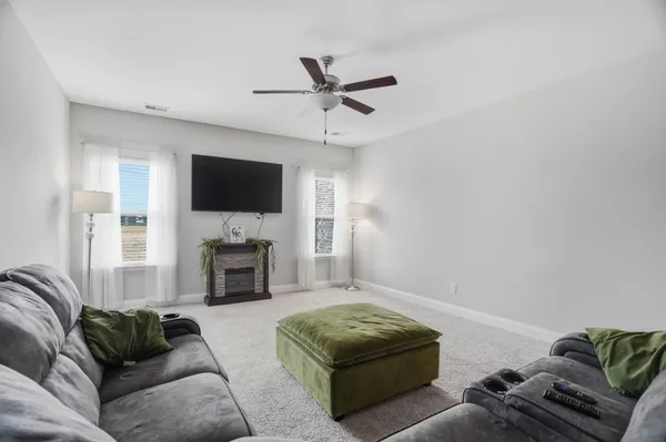 a living room with furniture a fireplace and a flat screen tv