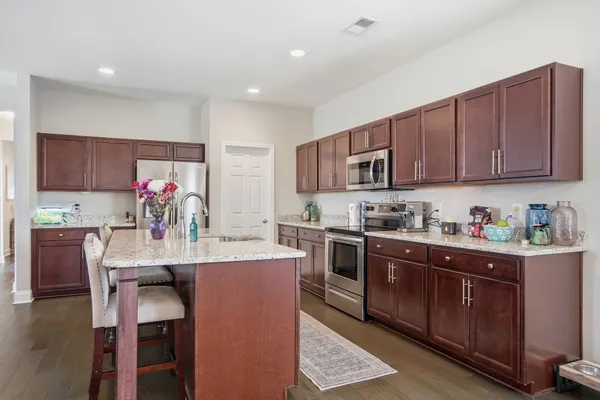 a kitchen with granite countertop a sink stove and cabinets