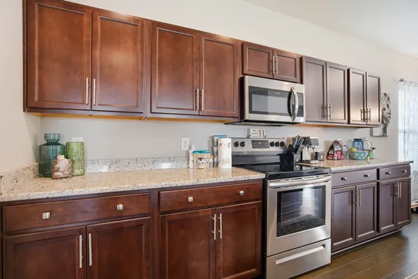 a kitchen with stainless steel appliances granite countertop a sink a stove and cabinets