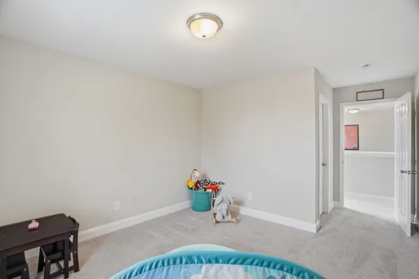 a bedroom with a bed a flat screen tv and gym equipment