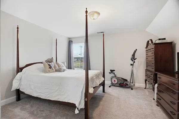 a bedroom with a bed and a flat tv screen on the dresser