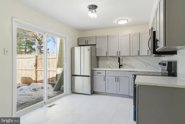a kitchen with white cabinets and refrigerator