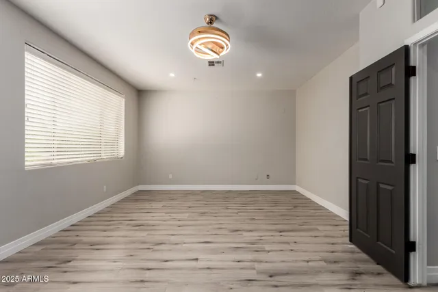 a view of an empty room with wooden floor
