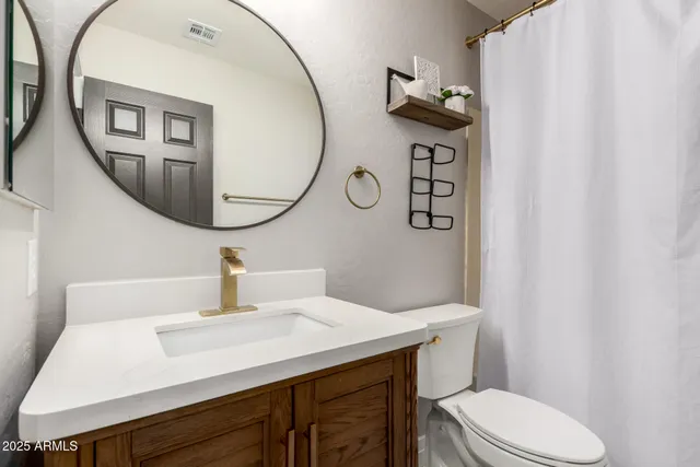 a bathroom with a sink a toilet and a mirror