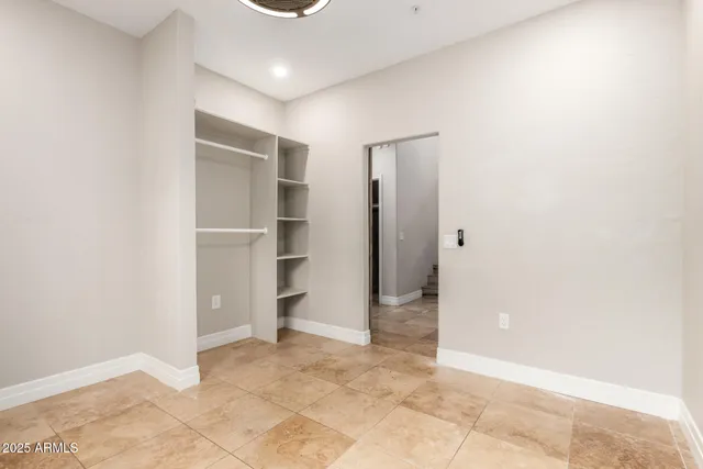 an empty room with closet and windows