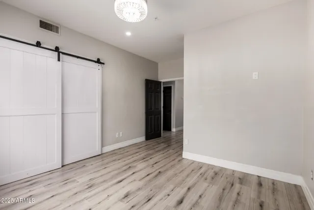 a view of an empty room with wooden floor