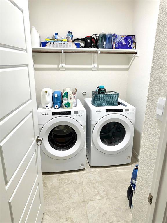 324 Revolution Road Fate, TX 75189 - Photo 14 of 15 Dedicated laundry area featuring tile flooring, white walls, and a built-in shelf with a hanging rod