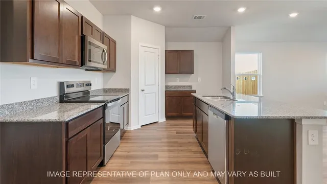 a view of a kitchen with a sink and a refrigerator