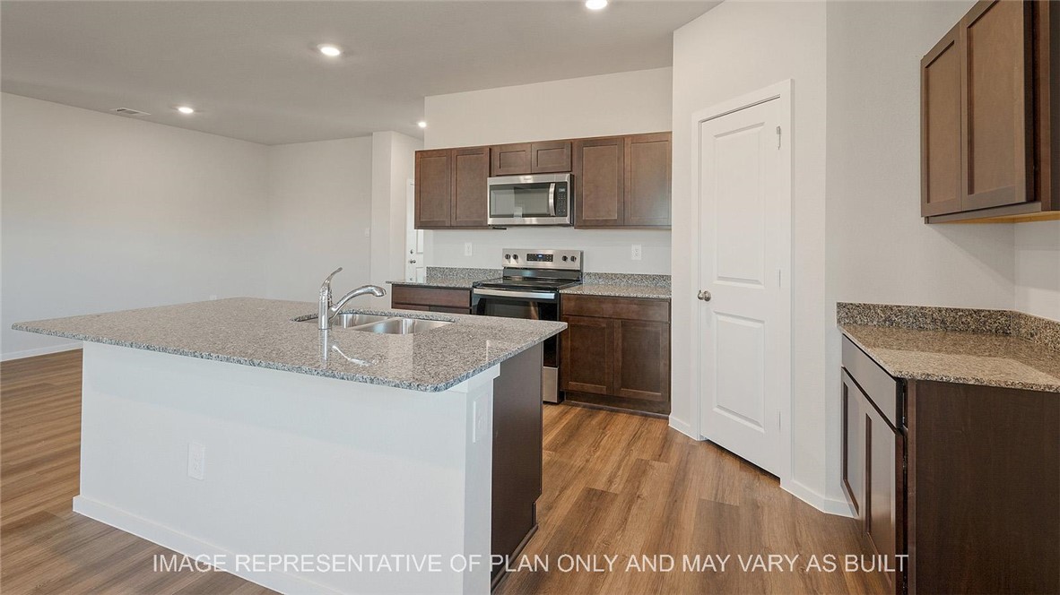 5416 Bear Run Bryan, TX 77807 - Photo 5 of 19 a kitchen with stainless steel appliances granite countertop a sink stove and refrigerator
