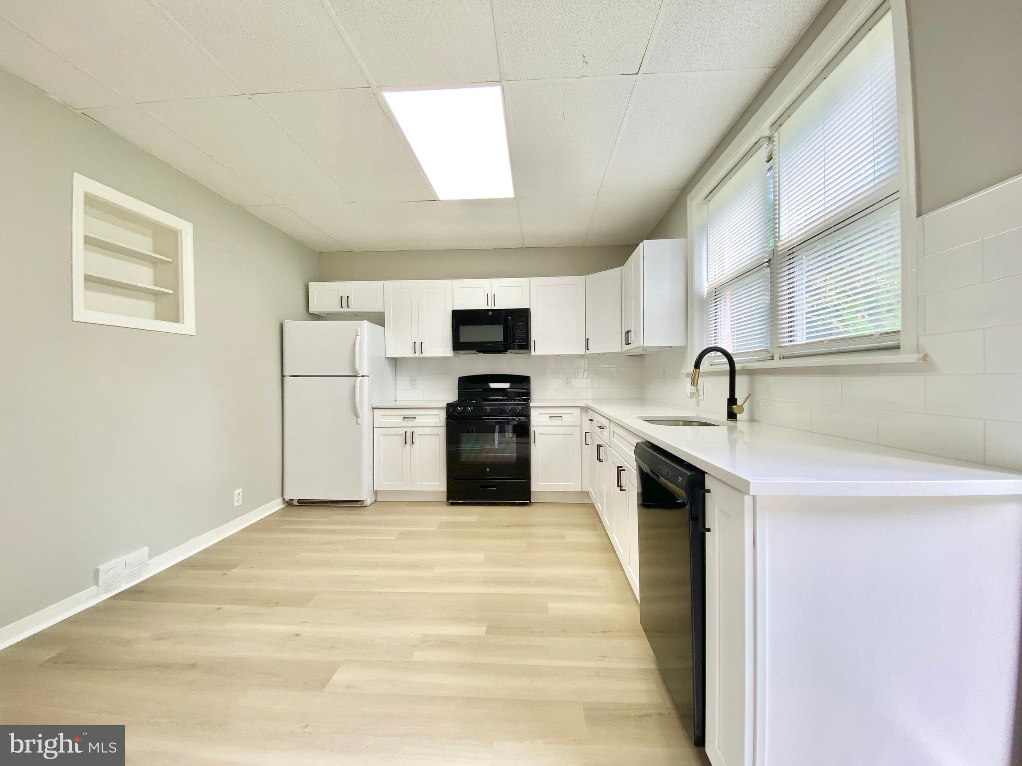 a kitchen with stainless steel appliances a refrigerator sink and microwave