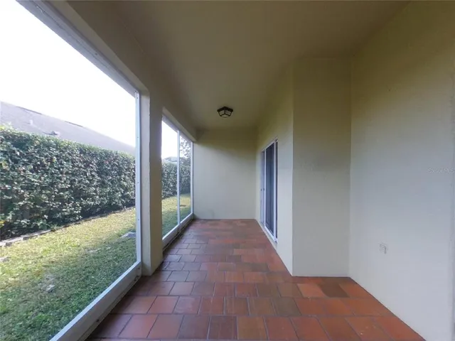 a view of a big room with wooden floor and windows