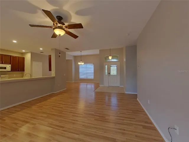 a view of an empty room with window and wooden floor