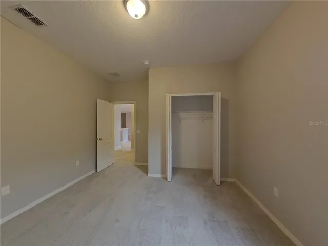 a view of an empty room and closet area