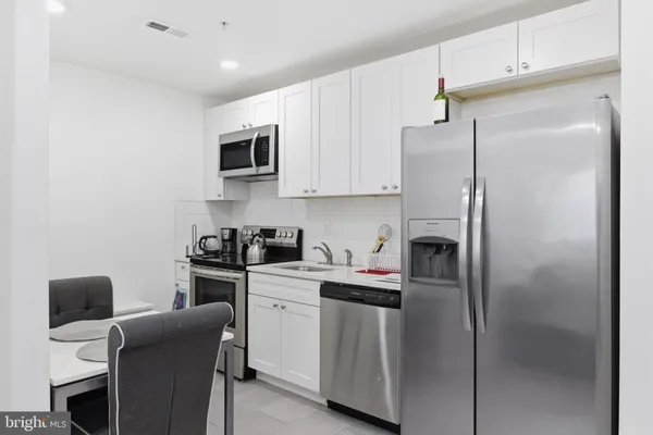 a kitchen with stainless steel appliances a refrigerator stove microwave and sink