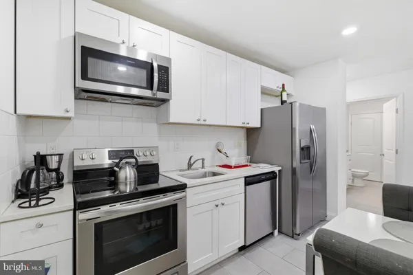 a kitchen with stainless steel appliances a stove microwave and sink