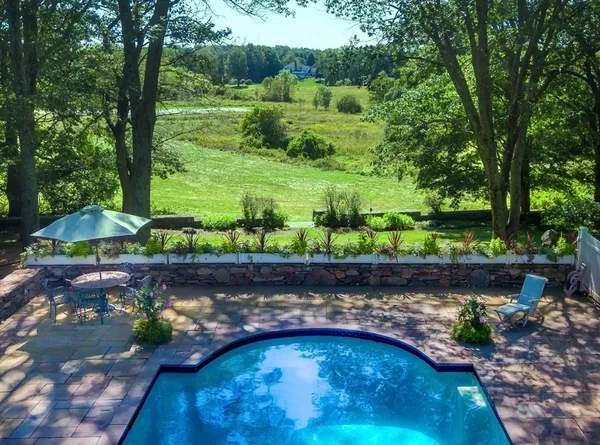 an aerial view of a house with a yard and large trees