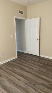 a view of an empty room with wooden floor