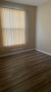 a view of a room with wooden floor and a window