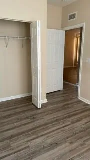 a view of empty room with wooden floor