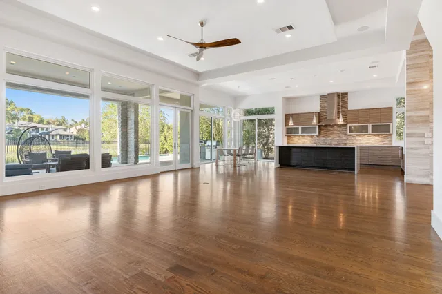 a kitchen with stainless steel appliances kitchen island granite countertop a refrigerator a stove a sink and dishwasher with wooden floor