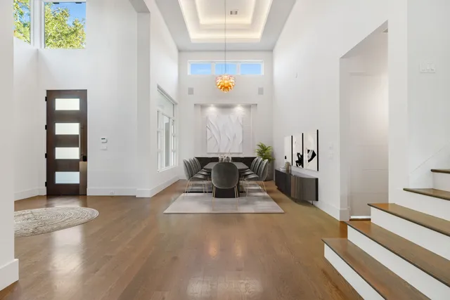 a view of an empty room with wooden floor and a ceiling fan