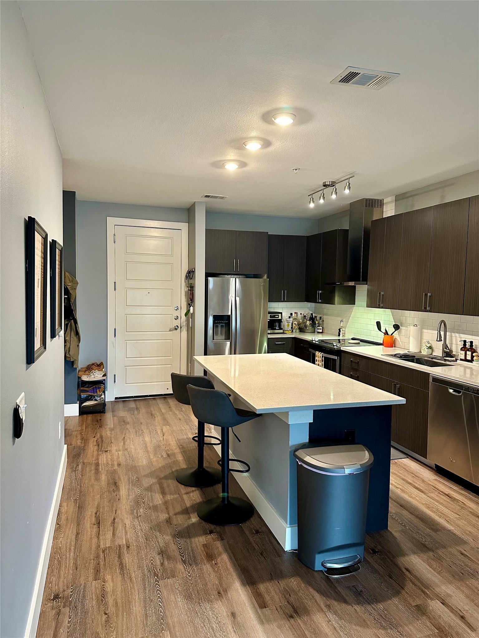 6444 Burnet Road, Unit 203 Austin, TX 78757 - Photo 5 of 30 Kitchen featuring a center island with a light-colored countertop, dark wood cabinetry, stainless steel appliances, and recessed lighting