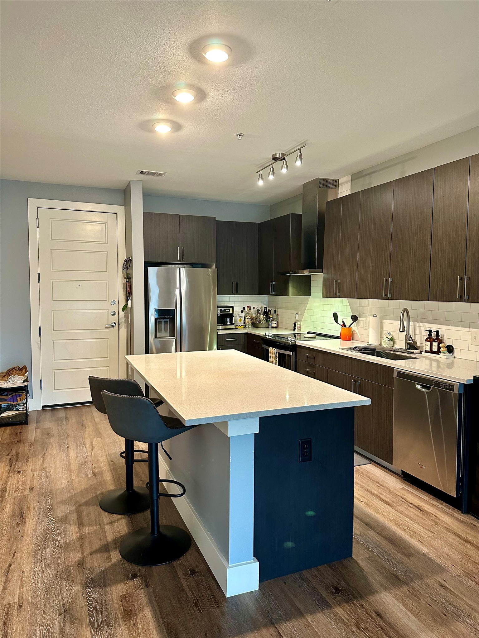 6444 Burnet Road, Unit 203 Austin, TX 78757 - Photo 6 of 30 Modern kitchen featuring a white quartz island, stainless steel appliances, dark wood cabinetry, and recessed lighting