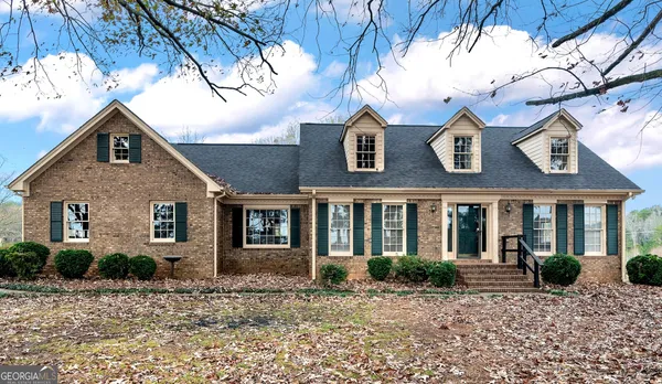 a view of a brick house with large windows and a small yard
