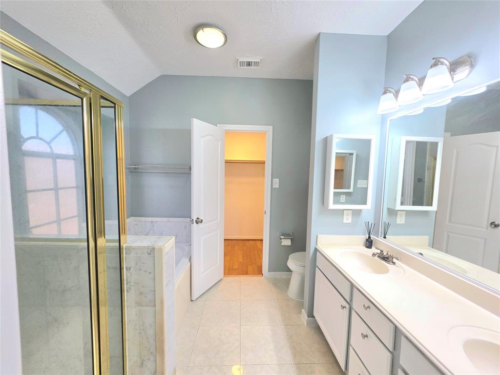 13618 Sablegrove Lane Houston, TX 77014 - Photo 15 of 30 a spacious bathroom with a double vanity sink and a mirror