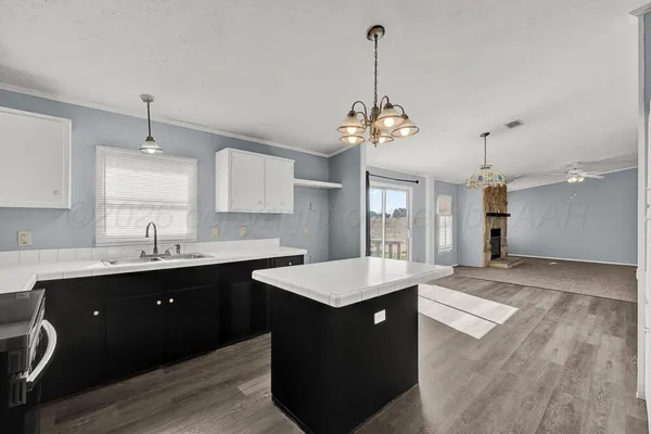 a large kitchen with kitchen island a sink stainless steel appliances and cabinets