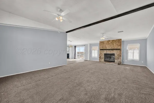 an empty room with fireplace and windows