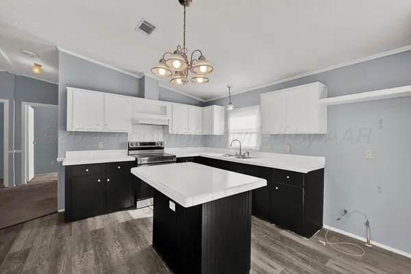 a kitchen with a center island white cabinets and appliances